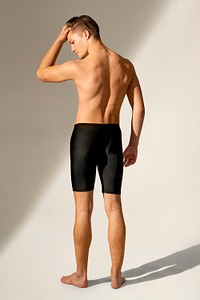 Man mockup psd in black swim shorts summer apparel full body rear view
