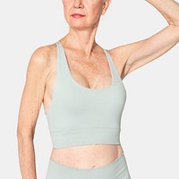 Healthy senior woman in mint green sports bra and leggings