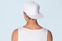 Teenage boy in white snapback cap and tank top street fashion shoot rear view