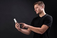 Man wearing a black t-shirt holding his smartphone 