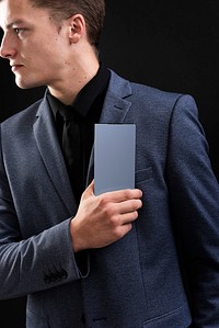 Businessman in suit holding his smartphone device 
