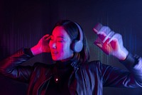 Woman listening to music with wireless headphones neon light
