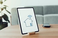 Digital tablet screen mockup psd on a wooden table with smart home controller