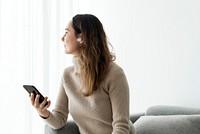 Woman wearing wireless earbuds and using a mobile phone