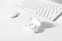 White wireless earbuds with computer keyboard