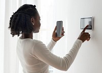 Woman pressing on smart home automation panel monitor