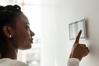 Woman pressing on smart home automation panel monitor