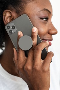 Round phone grip behind the mobile with African American woman talking on the phone