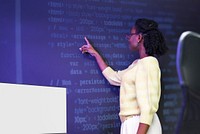 Woman analysing binary code on virtual screen