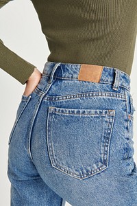 Woman wearing blue jeans with a brown tag 