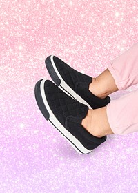 Girl's feet in black sneakers studio shot