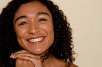 Curly hair woman smiling, beige background