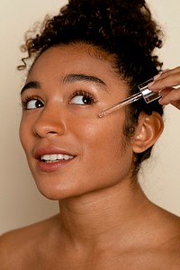 Woman applying serum to face