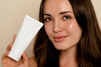 Woman holding face moisturizer tube