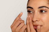 Woman applying lens on eye