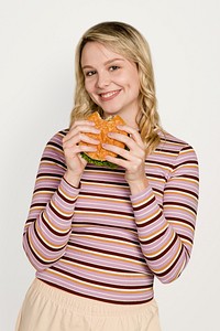 Happy woman eating a hamburger for lunch