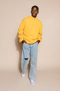 Handsome young man in yellow sweater and jeans