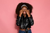 Shy woman covering her eyes, pink background