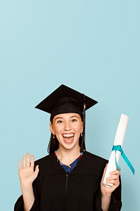 Woman wearing regalia holding her degree for graduation