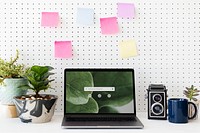 Laptop screen mockup psd on plant parent table home office