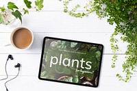 Tablet screen mockup psd on plant parent table flat lay