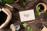 Paper mockup psd on wooden table with plants flat lay