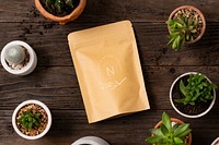 Pouch bag mockup psd on wooden table with plants flat lay