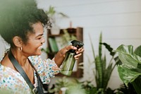 Small business worker misting plants with a water spray