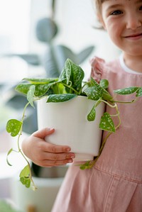 Happy little girl at home with indoor plants