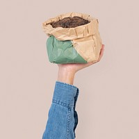 Hand mockup psd holding kraft paper plant pot green packaging