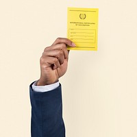 Covid-19 vaccine certificate mockup psd held by a businessman’s hand