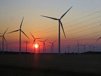 Wind farm at sunset. Original public domain image from <a href="https://commons.wikimedia.org/wiki/File:Sunset_(19957100704).jpg" target="_blank">Wikimedia Commons</a>