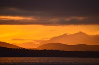 sunset in a cloudy evening at Olympic Mountains from Seattle waterfront. Original public domain image from Wikimedia Commons