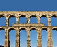The central part of the roman aqueduct, with the niche and the statue of Madonna and Child, Segovia, Spain. Original public domain image from <a href="https://commons.wikimedia.org/wiki/File:Aqueduct_Segovia_statue.jpg" target="_blank" rel="noopener noreferrer nofollow">Wikimedia Commons</a>
