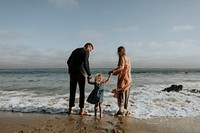 Happy family holding hands at the beach on vacation