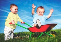 Two toddlers are playing together in the park.