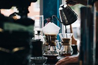 A person pouring water into a jug with a coffee filter. Original public domain image from Wikimedia Commons