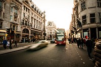 Time lapse shot of busy London street, silver car, red double decker bus pedestrians on sidewalk. Original public domain image from Wikimedia Commons