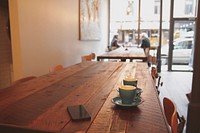 A view of the table top at a Caf&eacute; with two elderly people sitting together in the background. Original public domain image from Wikimedia Commons