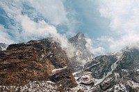 A high mountain top towering over two other peaks under a cloudy sky. Original public domain image from <a href="https://commons.wikimedia.org/wiki/File:Three_mountain_peaks_(Unsplash).jpg" target="_blank" rel="noopener noreferrer nofollow">Wikimedia Commons</a>