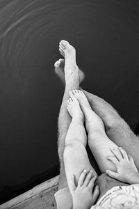 Child sits on lap of parent as their legs dangle off into the water. Original public domain image from <a href="https://commons.wikimedia.org/wiki/File:Summer_Waning_(Unsplash).jpg" target="_blank" rel="noopener noreferrer nofollow">Wikimedia Commons</a>