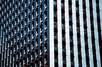 The corner of a skyscraper with small orange overhangs over its windows. Original public domain image from Wikimedia Commons