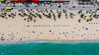 drone shot of beach with people,palm trees and blue umbrellas. Original public domain image from <a href="https://commons.wikimedia.org/wiki/File:Floridas_Streets_(Unsplash).jpg" target="_blank">Wikimedia Commons</a>