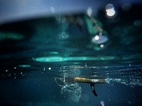 An underwater shot of a surfboard's fin in the blue Mediterranean Sea. Original public domain image from Wikimedia Commons