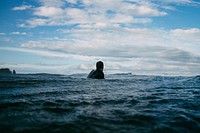 Person floating in the ocean at Piha Beach. Original public domain image from Wikimedia Commons