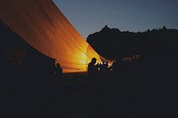 Silhouette photo of people preparing balloon. Original public domain image from Wikimedia Commons