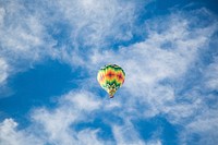 Colorful hot air balloon flies across a bright blue sky. Original public domain image from Wikimedia Commons