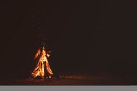 Burning bonfire with sparks and embers flying up. Original public domain image from Wikimedia Commons