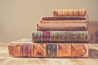 Pile of old books on the table. Original public domain image from Wikimedia Commons