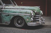 Cropped side view of a vintage car's front end with paint chipped off.. Original public domain image from Wikimedia Commons